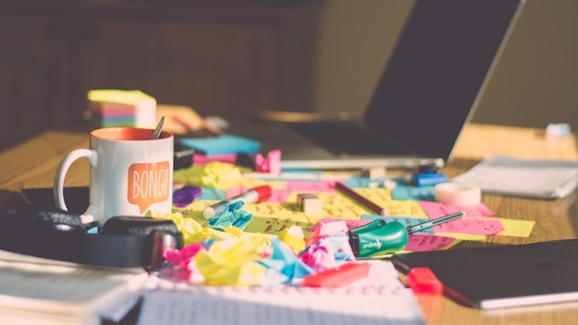 Bureau de travail d’un entrepreneur avec notes et carnet illustrant l’organisation adaptée au TDAH